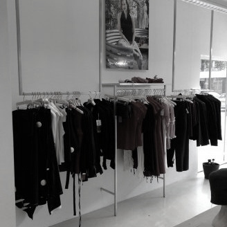 Winkelinterieur met rvs kledingrekken en staanders
